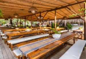 Restaurante La Mar en Isla del Encanto, espacio abierto con mobiliario de madera para celebraciones informales
