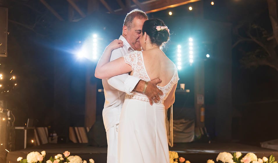 Pareja de recién casados bailando bajo luces cálidas durante recepción de boda en Isla del Encanto