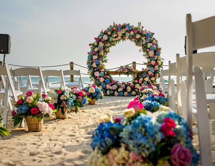 Arco floral decorado junto al mar para ceremonia nupcial en la playa de Isla del Encanto