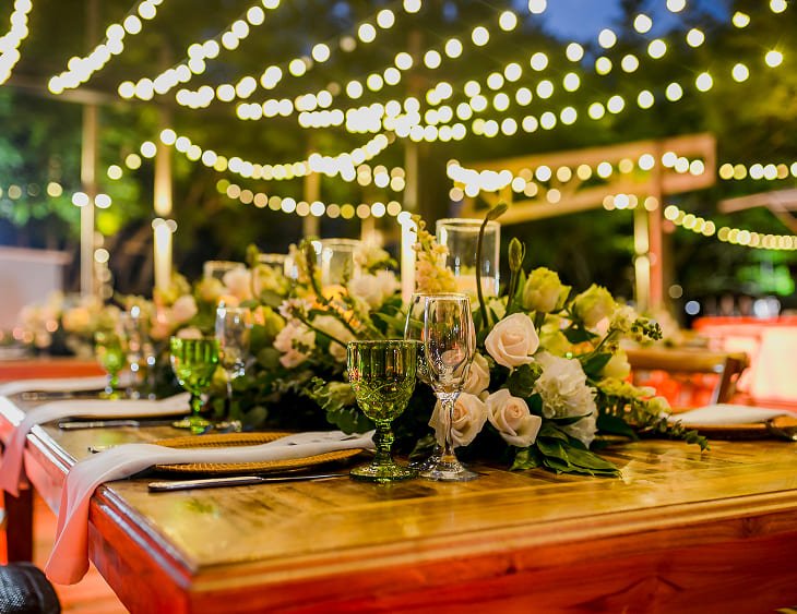 Montaje nocturno de boda con luces cálidas, flores blancas y ambiente romántico en la isla